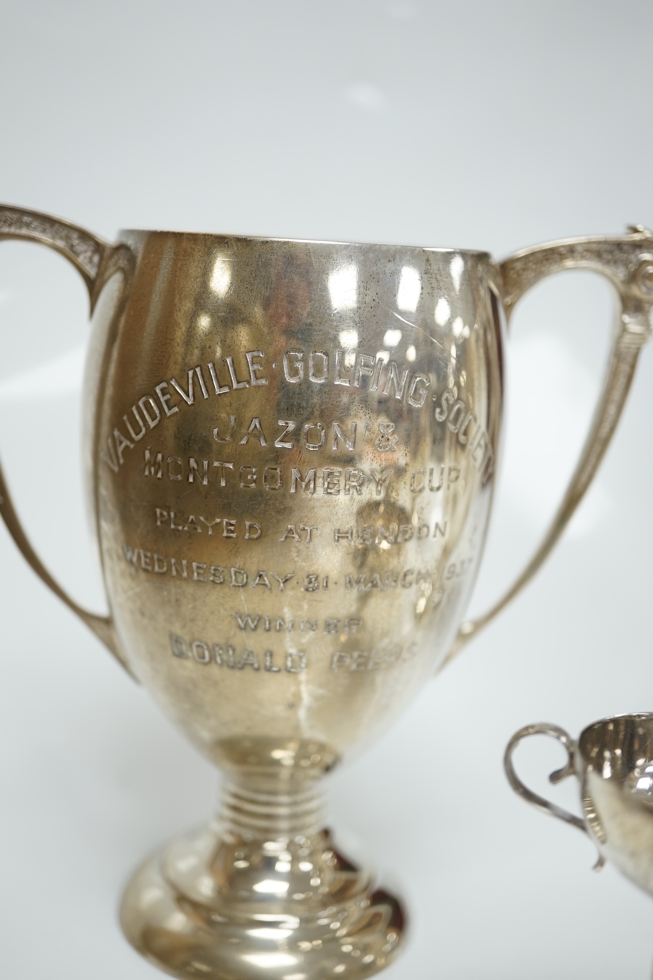 Five assorted small silver trophy cups including a pair by Edward Barnard & Sons, London, 1936, 12.7cm, 20.5cm. Condition poor to fair